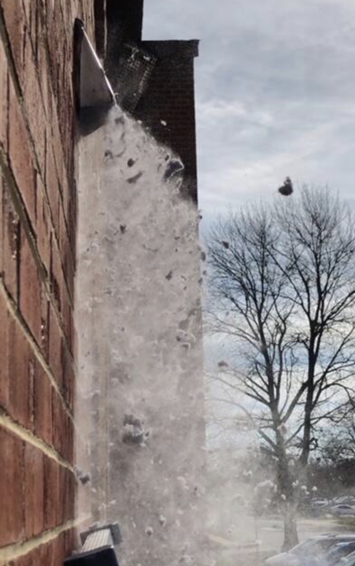 Lint blasting out of a dryer vent during a professional cleaning