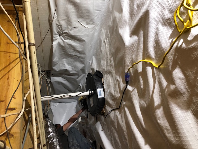Technician installing a sump pump during water damage work