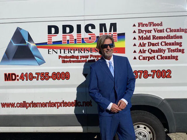 Prism Enterprises owner in front of the company service van